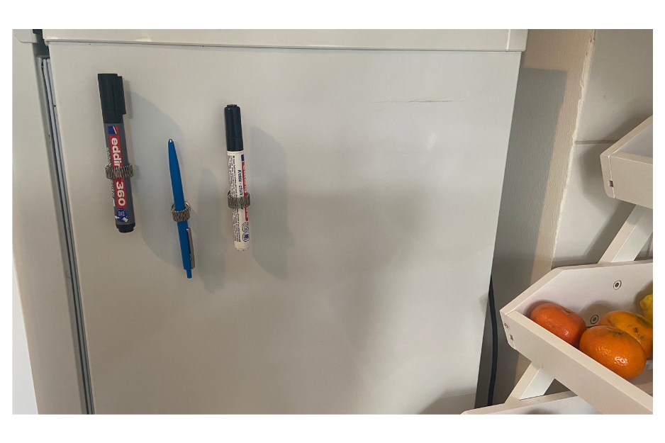 Verschiedene Stifte die mit einer Halterung am Kühlschrank festgemacht wurden